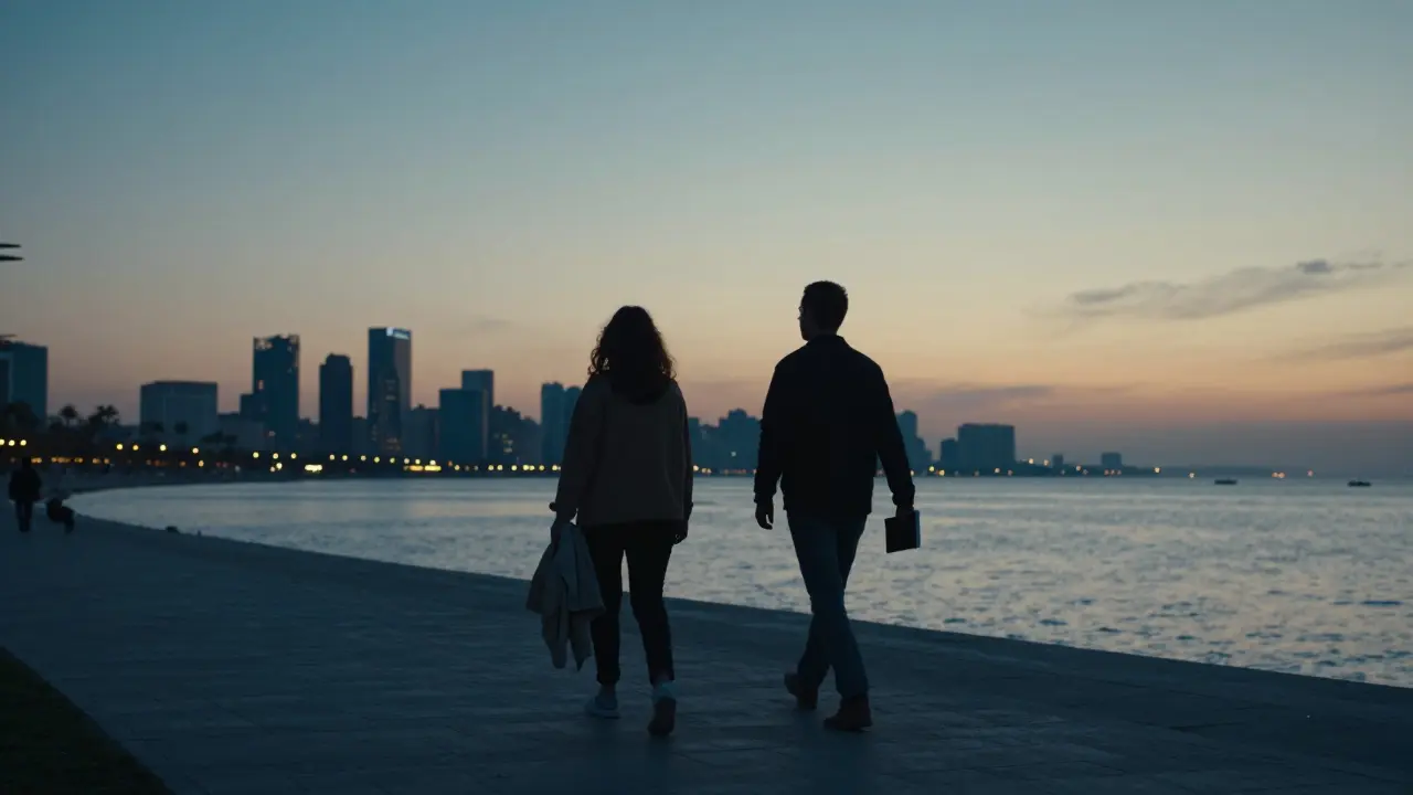 Two individuals walking side by side along the Corniche at dusk, silhouetted against the glowing city skyline.